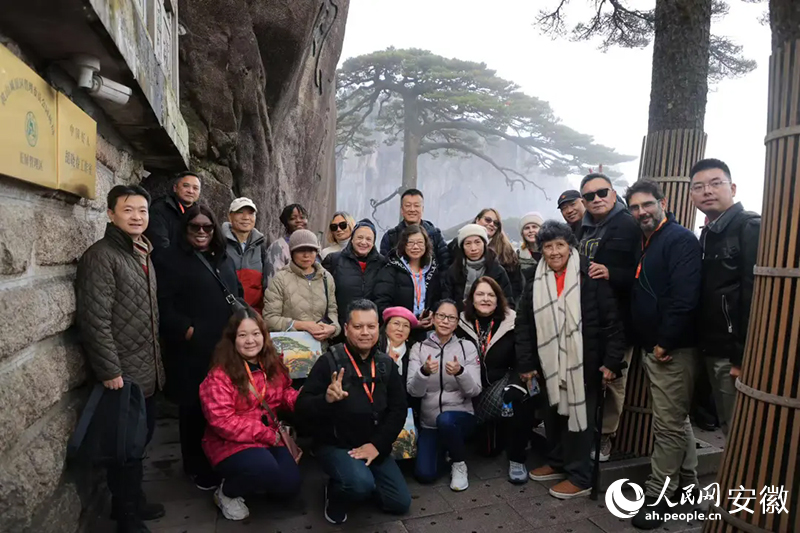 旅行商在黃山迎客松前合影。人民網(wǎng)記者 王曉飛攝