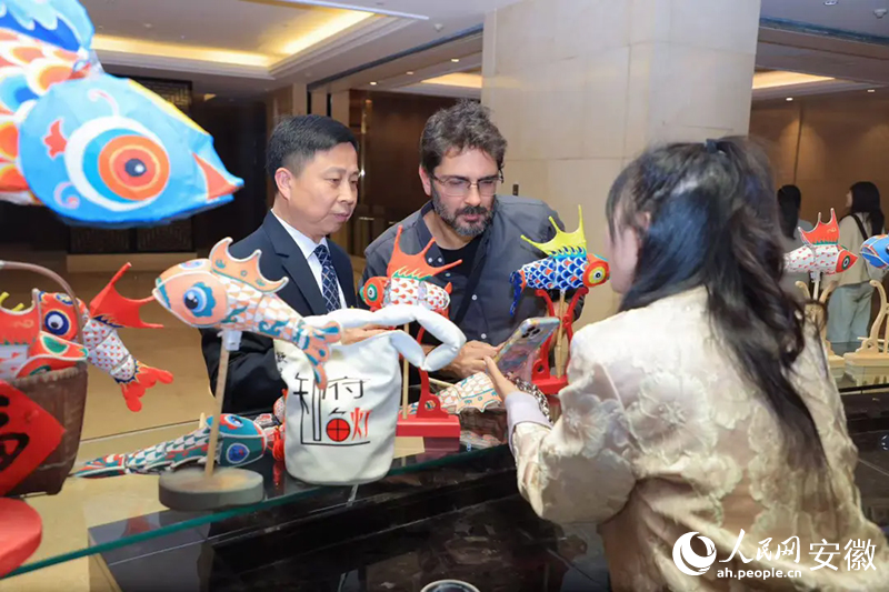 巴西旅行商米內(nèi)維諾·奧爾蒂斯·內(nèi)托·西爾維里奧（中）對(duì)魚(yú)燈充滿好奇。人民網(wǎng)記者 王曉飛攝