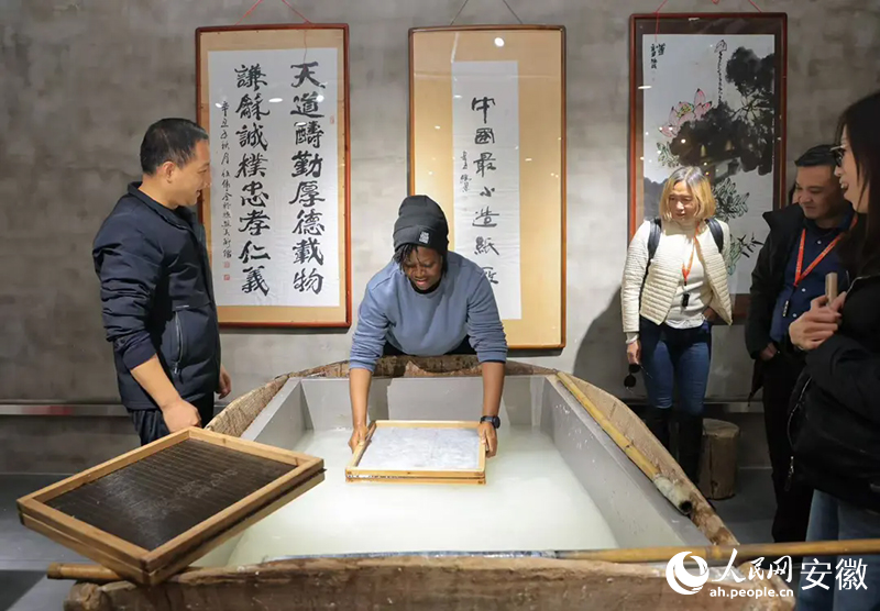 美國(guó)旅行商法紹拉·扎伊諾布·托沃布拉體驗(yàn)宣紙制作工藝。人民網(wǎng)記者 王曉飛攝